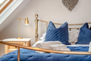 Une chambre à coucher comprenant un lit, une table de chevet, une lampe et un élément décoratif mural.