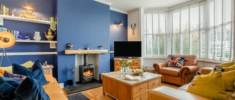A living room with a fireplace, a television, and a sofa.