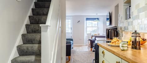 A staircase leading to a dining area with a kitchen visible in the background.