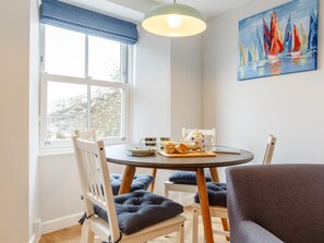 A dining area with a round table, chairs, a painting, and a view of the outdoors. - 2 Bed in Polruan (oc-82949) (Fowey)