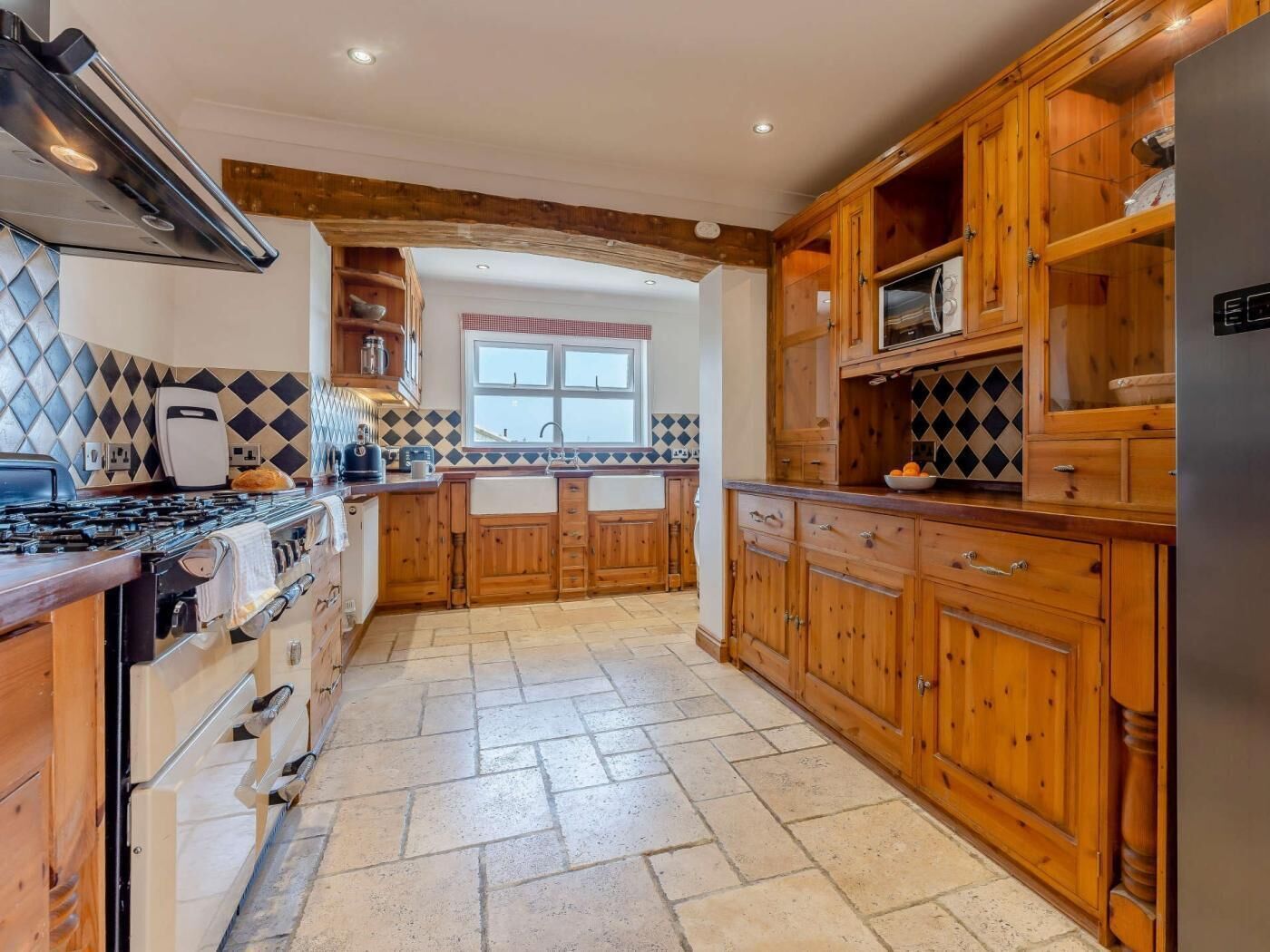 A kitchen with wooden cabinets, a stove, and a window.