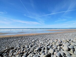 Ein Strand mit Kiesstreifen und blauem Himmel.