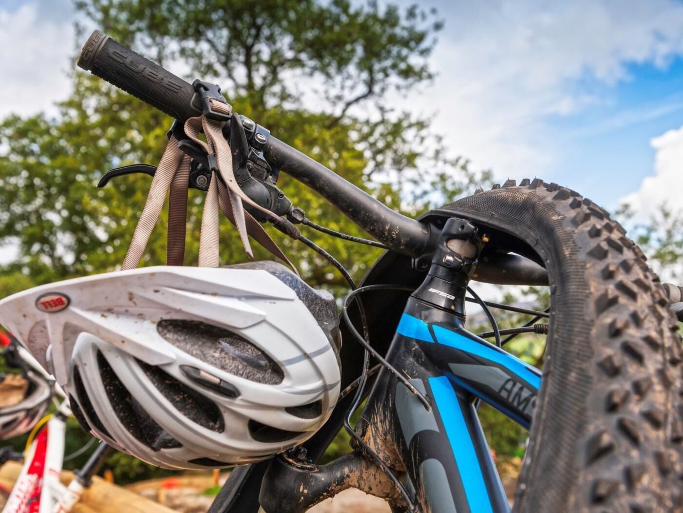 A close-up of a bicycle's handlebars, a white helmet, and a blue frame.
