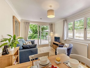 A cozy living room with a sofa, dining table, and a TV. - 2 Bed in Crewe (oc-83192) (Audlem)