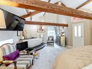 A bedroom with a large bed, a curved white sink, a chair, and a television. - 4 Bed in Leyburn (oc-83260) (Middleham)