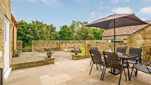 A patio with stone flooring, outdoor furniture, and a large umbrella. - 3 Bed in Great Ayton (oc-83328) (Great Ayton)