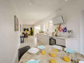 A modern kitchen with a dining area, a built-in oven, and a large window. - 2 Bed in Northallerton (oc-83398) (Brompton)