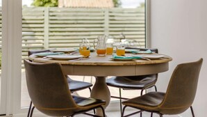 Ein runder Tisch mit Stühlen, einer Karaffe und Gläsern Orangensaft.