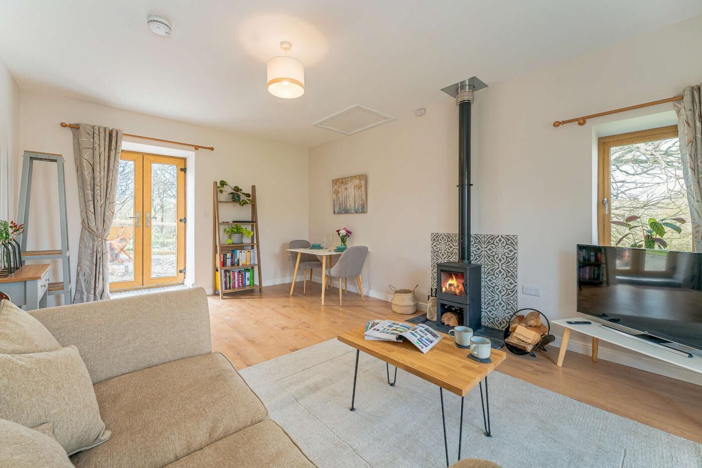 A living room with a sofa, a coffee table, a fireplace, a TV, and a bookshelf.