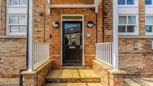 A brick building with a central entrance, white railings, and a visible door. - 2 Bed in Ripon (oc-83763) (Ripon)