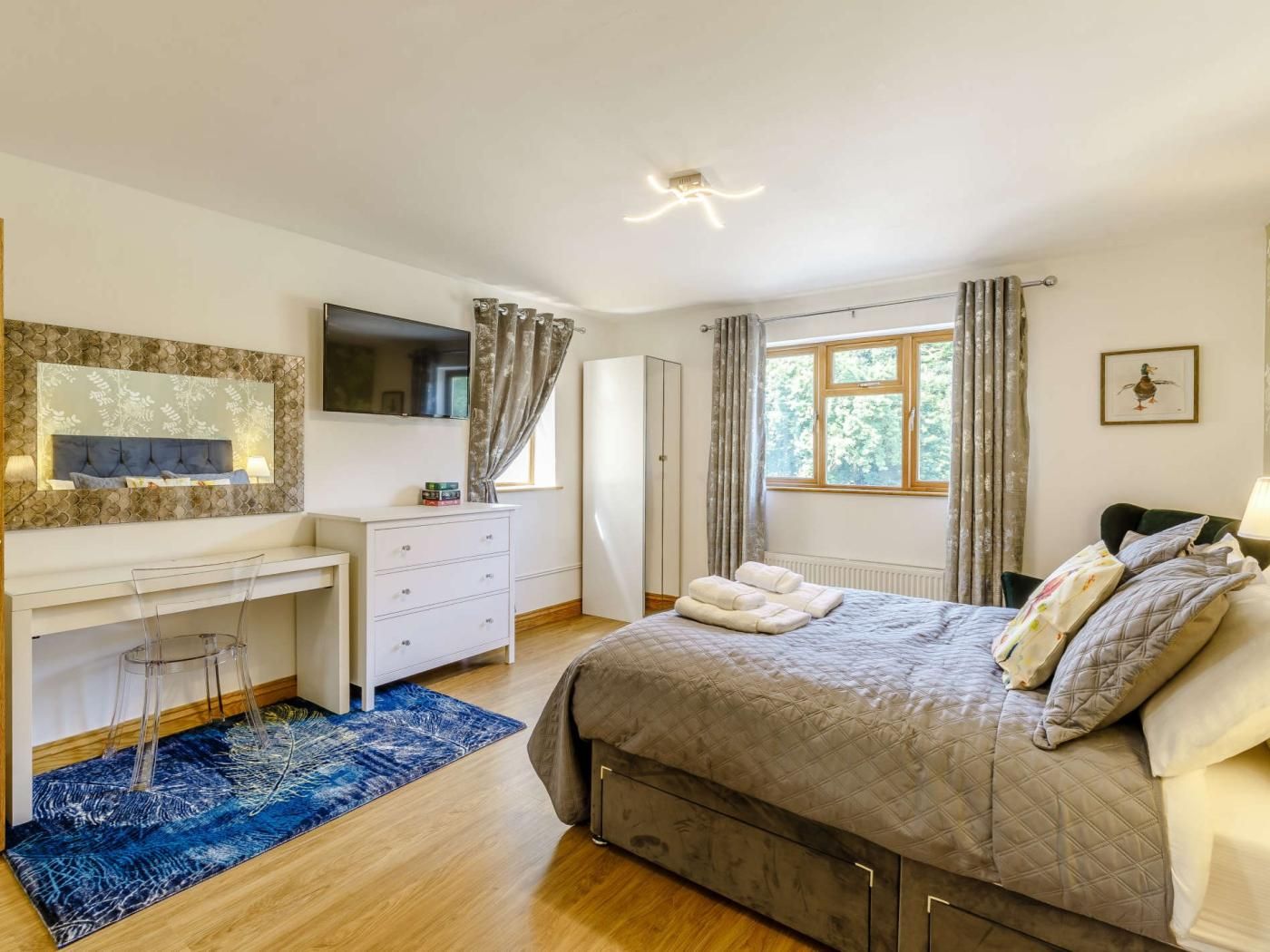Un dormitorio con cama, escritorio, silla, ventana y radiador.