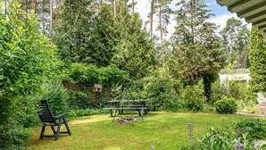 Ein Garten mit einer Bank, einem Picknicktisch und üppiger Bepflanzung.