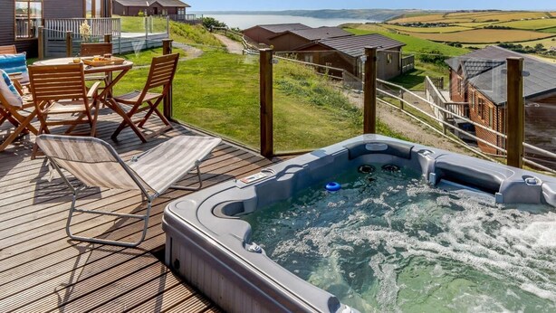 A hot tub on a deck with a view of the sea and hills. - 3 Bed in Torpoint (oc-83792) (Millbrook)