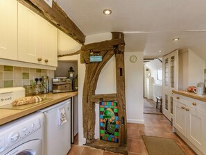 A kitchen with a rustic stone archway, a bread rack, a toaster, and a washing machine. - 1 Bed in Battle (oc-83845) (Sedlescombe)