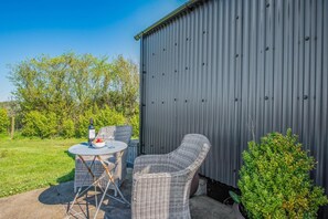 A patio with wicker furniture, a table, and a bottle of wine. - 1 Bed in Narberth (oc-83862) (Whitland)