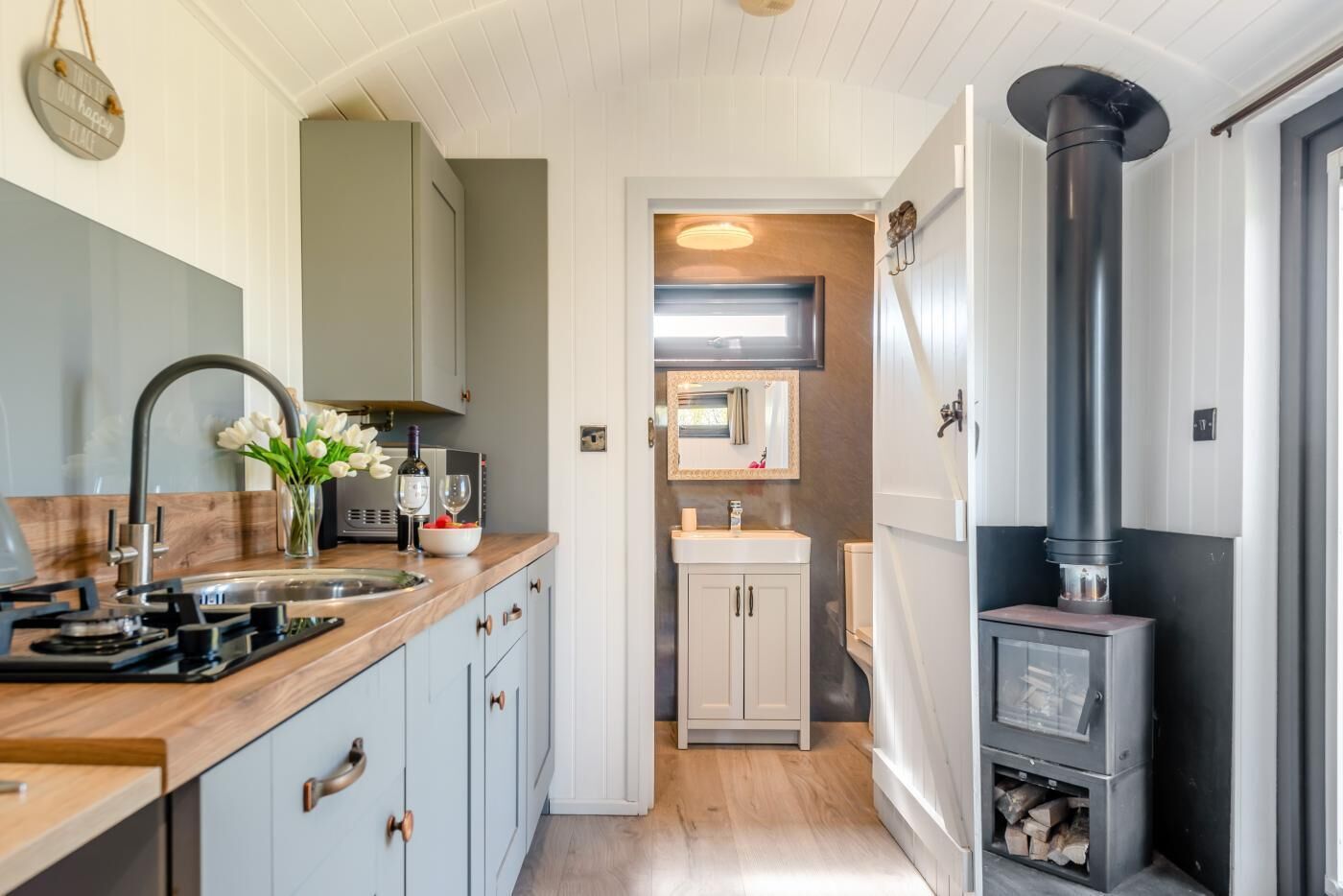 A compact kitchen with a built-in stove, a sink, and a small window.