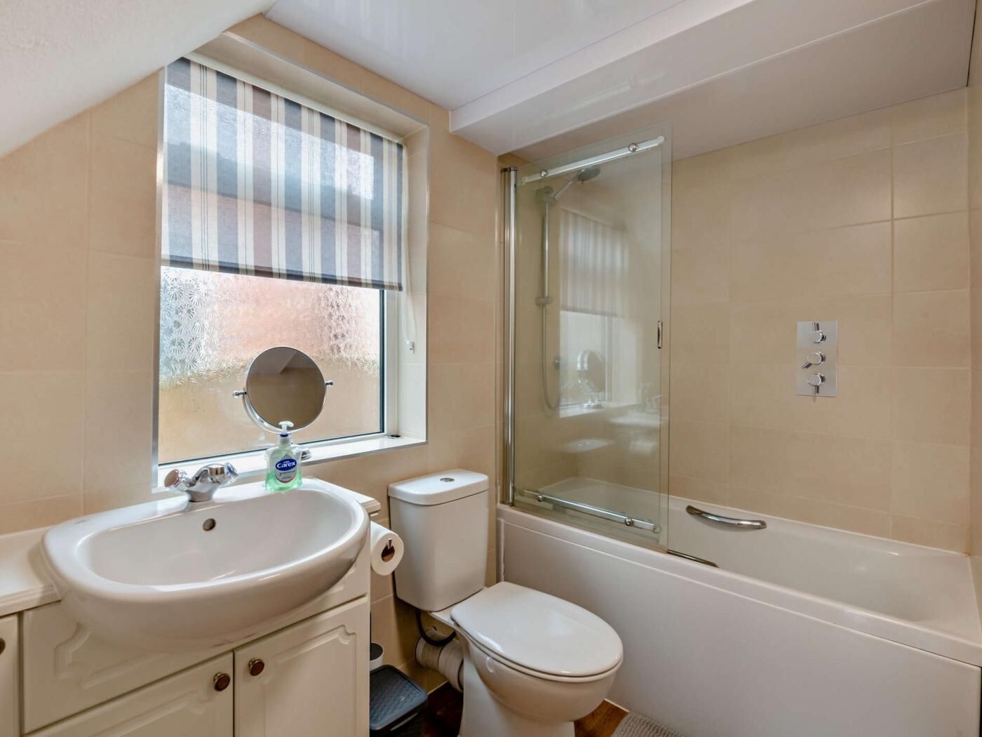 A bathroom with a sink, toilet, and glass-enclosed shower.