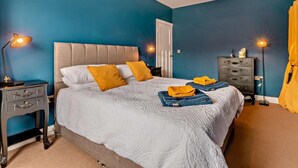 A bedroom with a bed, bedside tables, a dresser, and a lamp. - 3 Bed in Filey (oc-84007) (Filey)