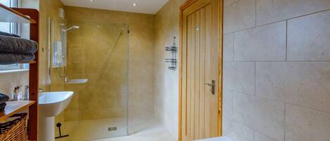 A modern bathroom with a bathtub, a shower, and a sink.