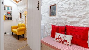 A room with a white textured wall, a yellow armchair, a red and white striped bed with a 'Welcome' pillow, and a small window with a picture. - 2 Bed in Bakewell (oc-85314) (Ashford in the Water)
