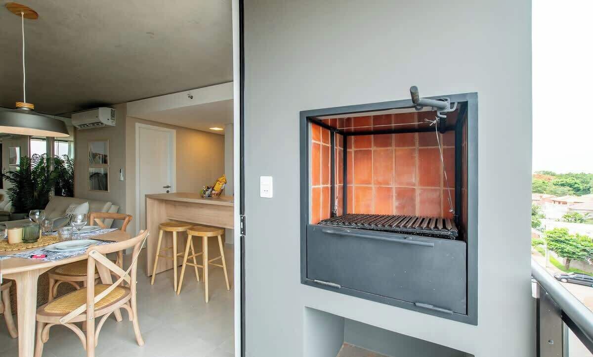 Ein Balkon mit Grill, ein Essbereich mit Holzmöbeln und eine Außenansicht.