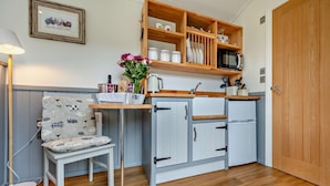 A compact kitchen with a wooden countertop, a microwave, a sink, and a chair. - 1 Bed in Penrith (oc-85531) (Deepdale)