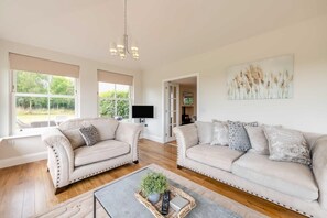 Ein geräumiges Wohnzimmer mit zwei Sofas, einem Couchtisch und einem Kamin.