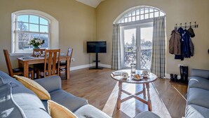 A living room with a dining table, a TV, a sofa, and a balcony with a view. - 2 Bed in Hawick (oc-86021) (Hawick)