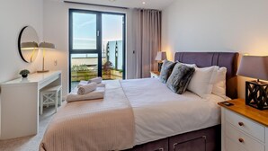 A hotel room with a bed, bedside tables, a desk, and a large window with a view. - 2 Bed in Ramsgate (oc-86126) (Ramsgate)