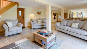 A spacious living area with a sofa set, a coffee table, and a staircase. - 4 Bed in Llandrindod Wells (oc-86118) (Llaithddu)
