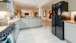 A modern kitchen with a central island, built-in oven, and stainless steel appliances. - 4 Bed in Llandrindod Wells (oc-86118) (Llaithddu)