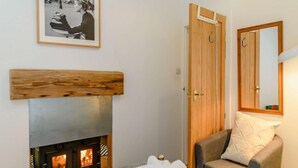 Ein Schlafzimmer mit Holz-Kopfteil, Kamin, einer Couch und einem Spiegel.