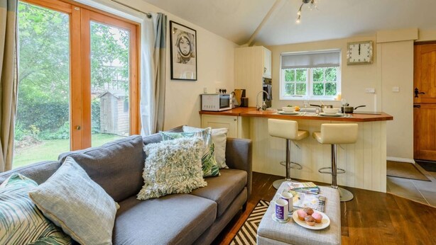 Ein gemütliches Wohnzimmer mit einer Couch, einem Couchtisch und einer Küchenzeile mit einer Bar.