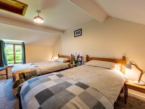 A room with two beds, a window with curtains, a ceiling fan, and a framed picture on the wall. - 4 Bed in Hereford (oc-86497) (Llanveynoe)