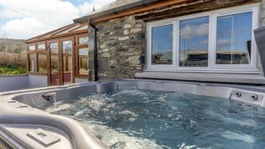 Ein Whirlpool mit Steinwand und Fenstern.
