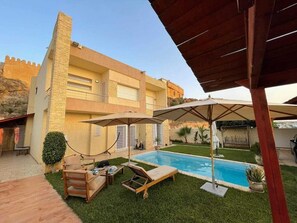 A two-story building with a swimming pool, outdoor seating, and a covered patio area. - Charming villa, not overlooked (Hammamet)