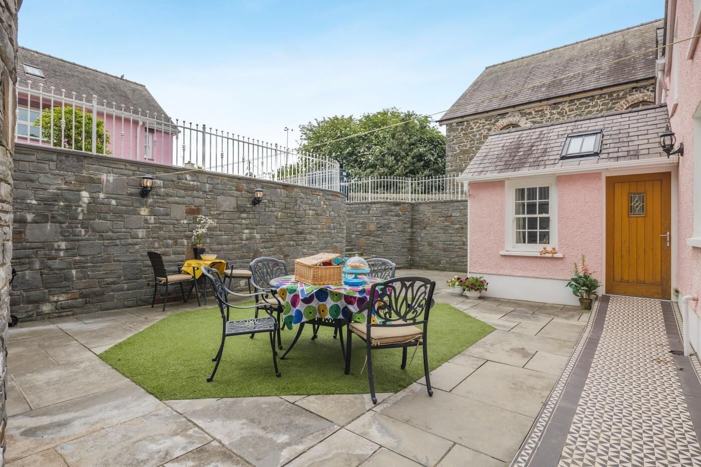 A patio with a table, chairs, and a basket of items.