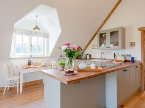 A kitchen with a wooden island, a window with a view, a sink, and cabinets. - 1 Bed in Ipswich (oc-86650) (Aldham)