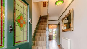 A staircase with striped carpet, a green door with a stained glass window, and a mirror on the wall. - 3 Bed in Broadstairs (oc-86736) (Broadstairs)