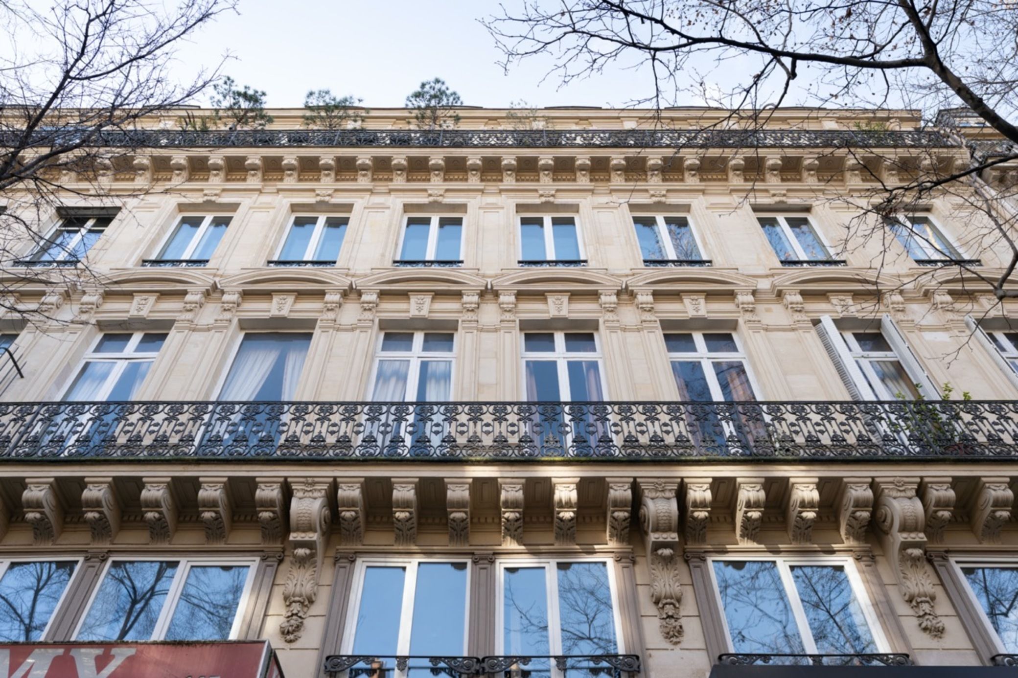 A multi-story building with a classical architectural style, featuring ornate balconies and large windows.