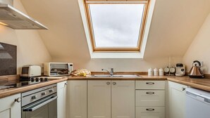 A kitchen with a skylight, a stove, a microwave, and a kettle. - 1 Bed in Hawarden (oc-86711) (Dobshill)