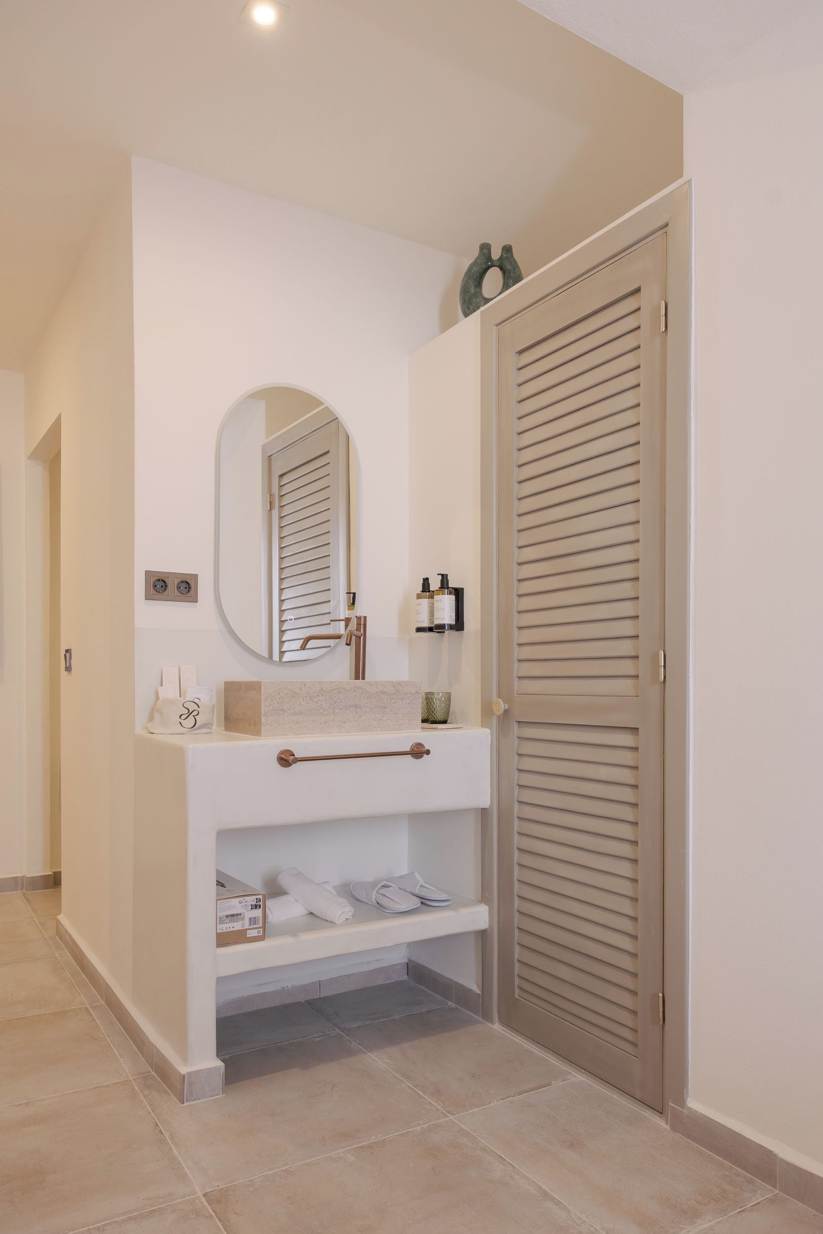A bathroom with a white vanity, a mirror, and a towel rack.