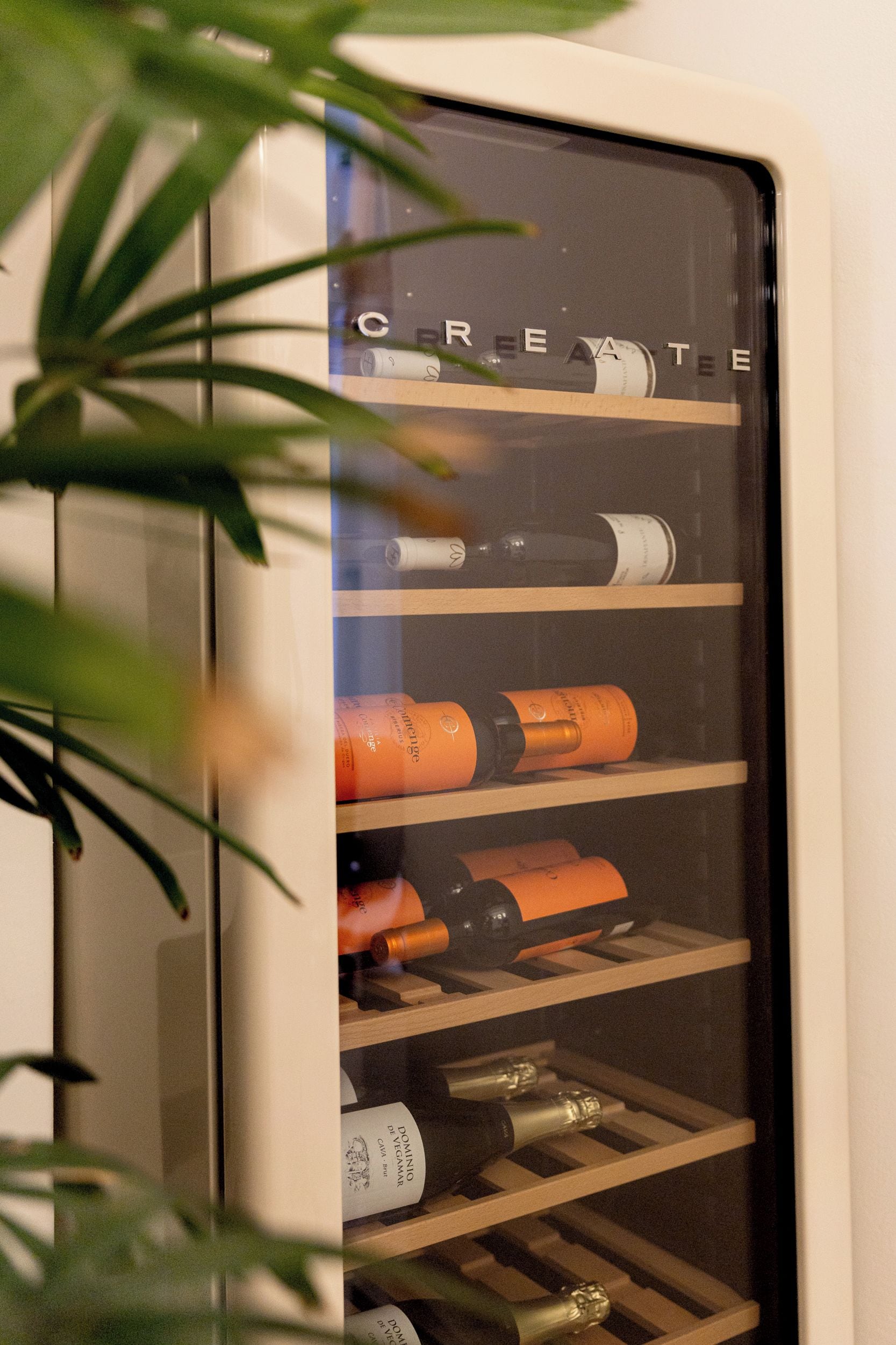 Una botellera con botellas, algunas etiquetadas 'DOMINO' y 'CAVA BRUT'.