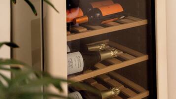 Una botellera con botellas, algunas etiquetadas 'DOMINO' y 'CAVA BRUT'.