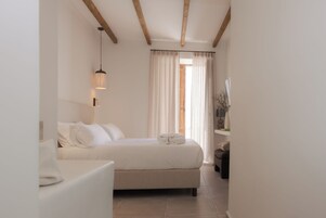 Un dormitorio con cama, mesita de noche y lámpara colgante.