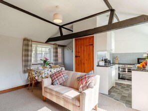 A cozy room with a sofa, a dining table, and a kitchen area. - 1 Bed in Norwich (oc-87414) (Hainford)
