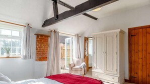Ein Schlafzimmer mit einem Bett, einem Kleiderschrank, einem Fenster und einer Tür.