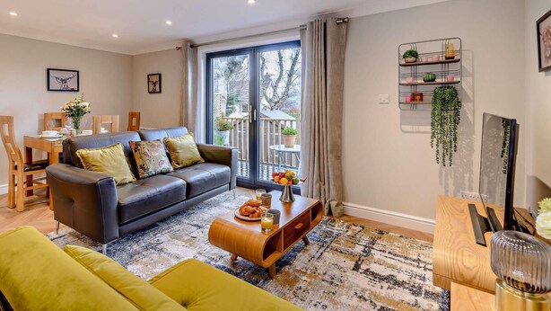 Un salon moderne comprenant un canapé, une table basse et un coin repas avec des chaises et une table.