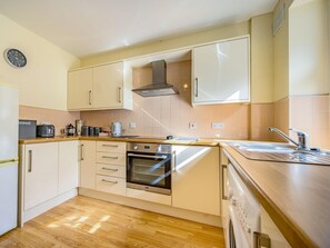 A compact kitchen with a built-in oven, a microwave, and a coffee maker. - 1 Bed in Cockermouth (oc-87480) (Cockermouth)