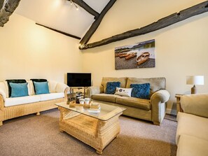 A living room with a television, two sofas, a coffee table, and a painting of boats on a wall. - 1 Bed in Cockermouth (oc-87480) (Cockermouth)